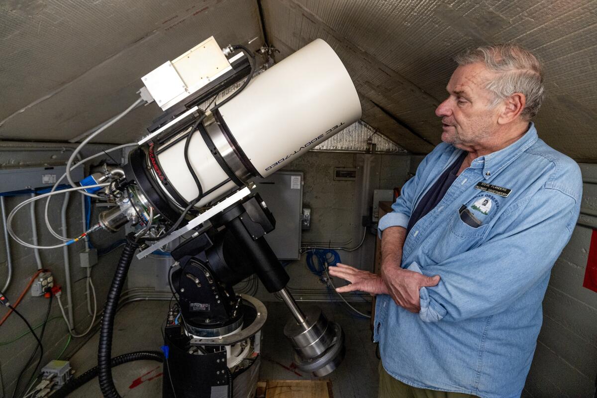 Steve Flanders shows the Gattini-IR telescope inside the small building of the Palomar Observatory.