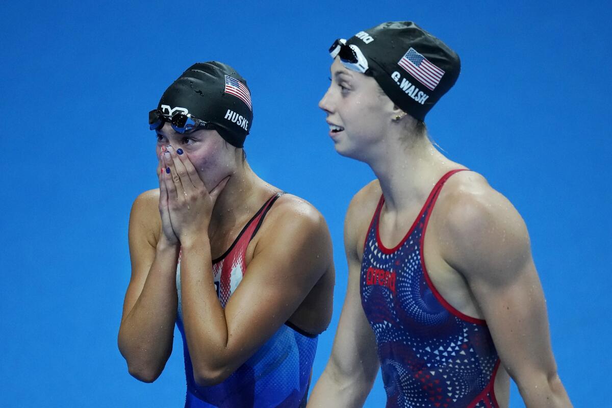 Torri Huske, left, of the United States, reacts after winning the women's 100m butterfly final