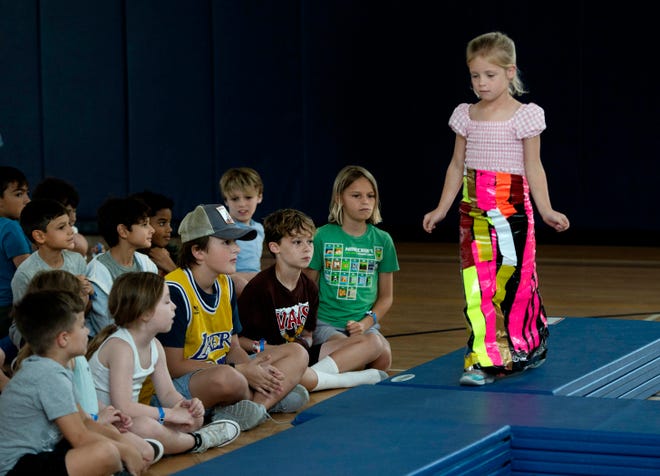 Lucy Parham, 5, shows off her tapestry dress during the Funky Fashion show during Camp Palm Beach at the Mandel Recreation Center July 10, 2024. Children ages 5 to 8 created using plastic bags. trash and tape.  The last day of the camp is July 26, 2024.