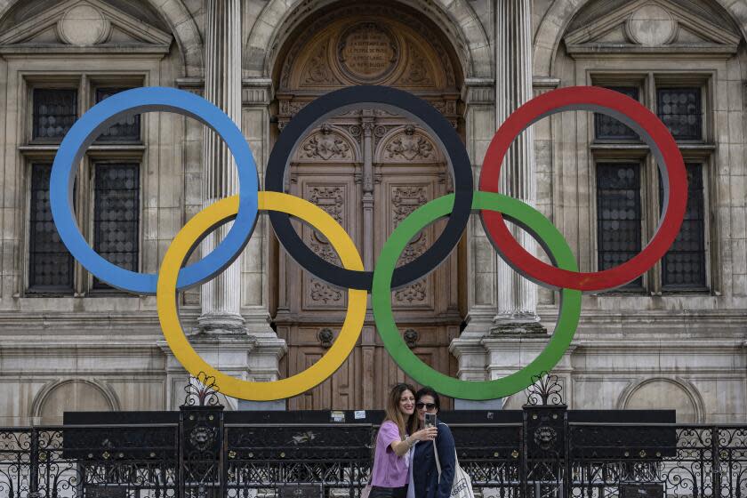 People take a picture of the Olympic rings in front of Paris City Hall, Paris.